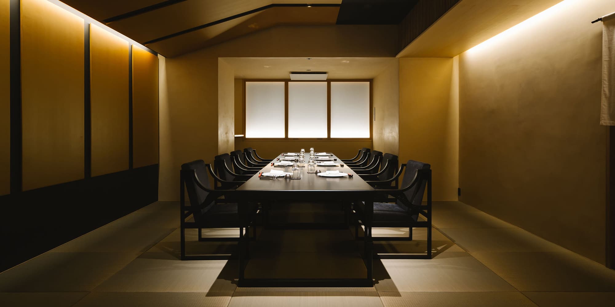 長テーブルに席が整えられた和モダンな宴会場 Banquet Room 1115 の内観