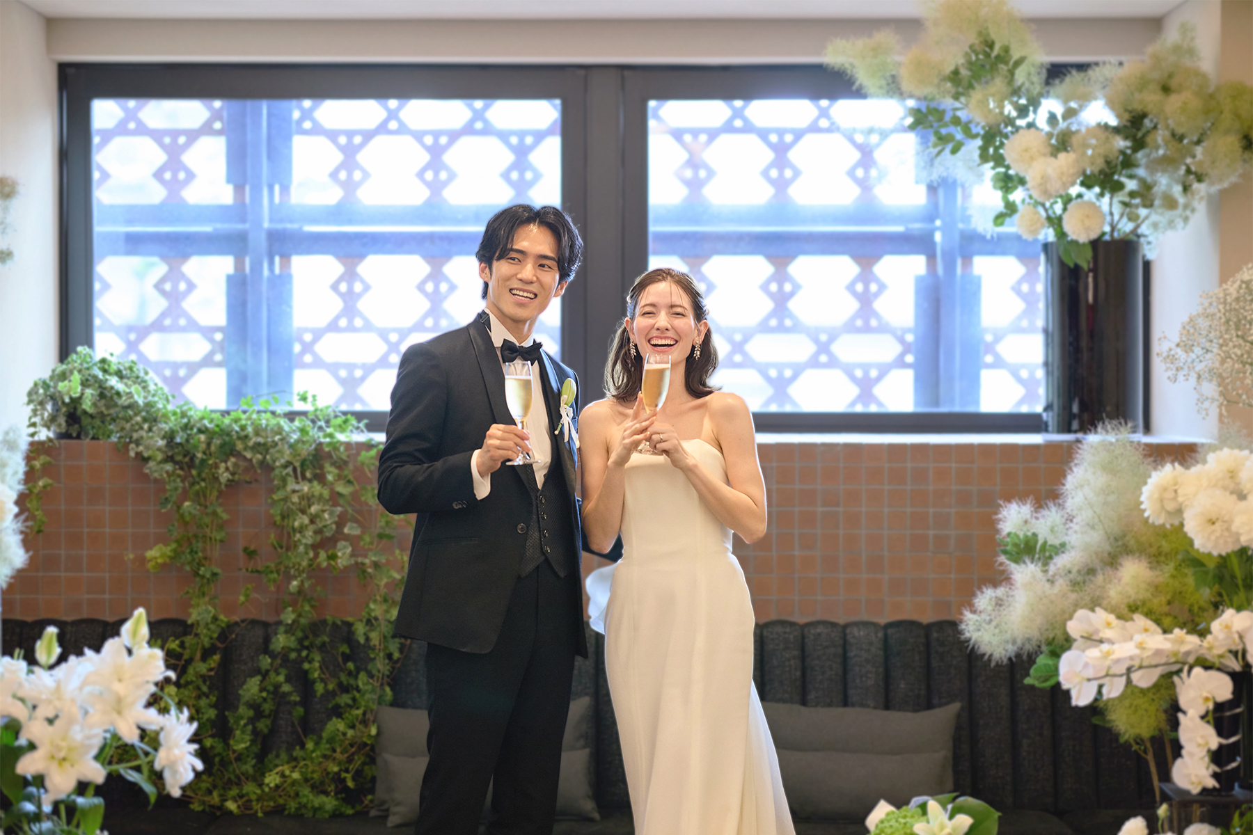 シャンパングラスを掲げ乾杯する新郎新婦